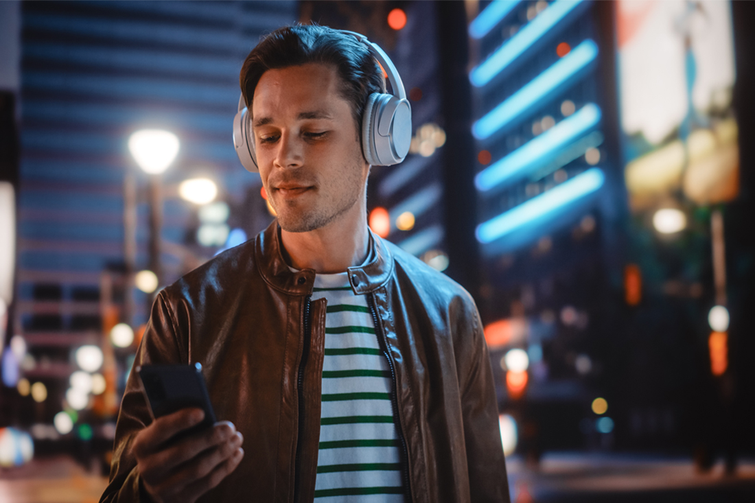 Man walking through city streets listening to an entertainment entrepreneur podcast