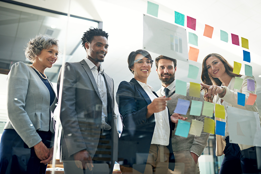 employees putting post it notes on glass in living out the purpose of work