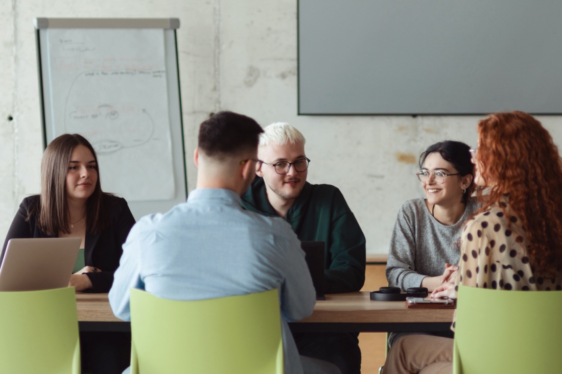 A group of people sit around a conference table.