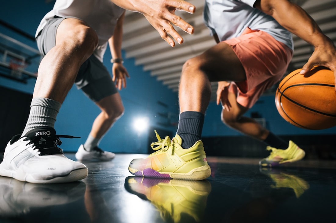 Two male athletes play basketball while wearing Xero Shoes