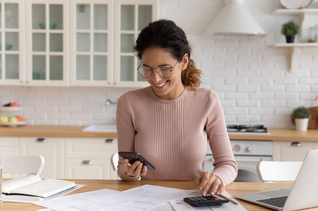 woman work from home makes calculations on calculator