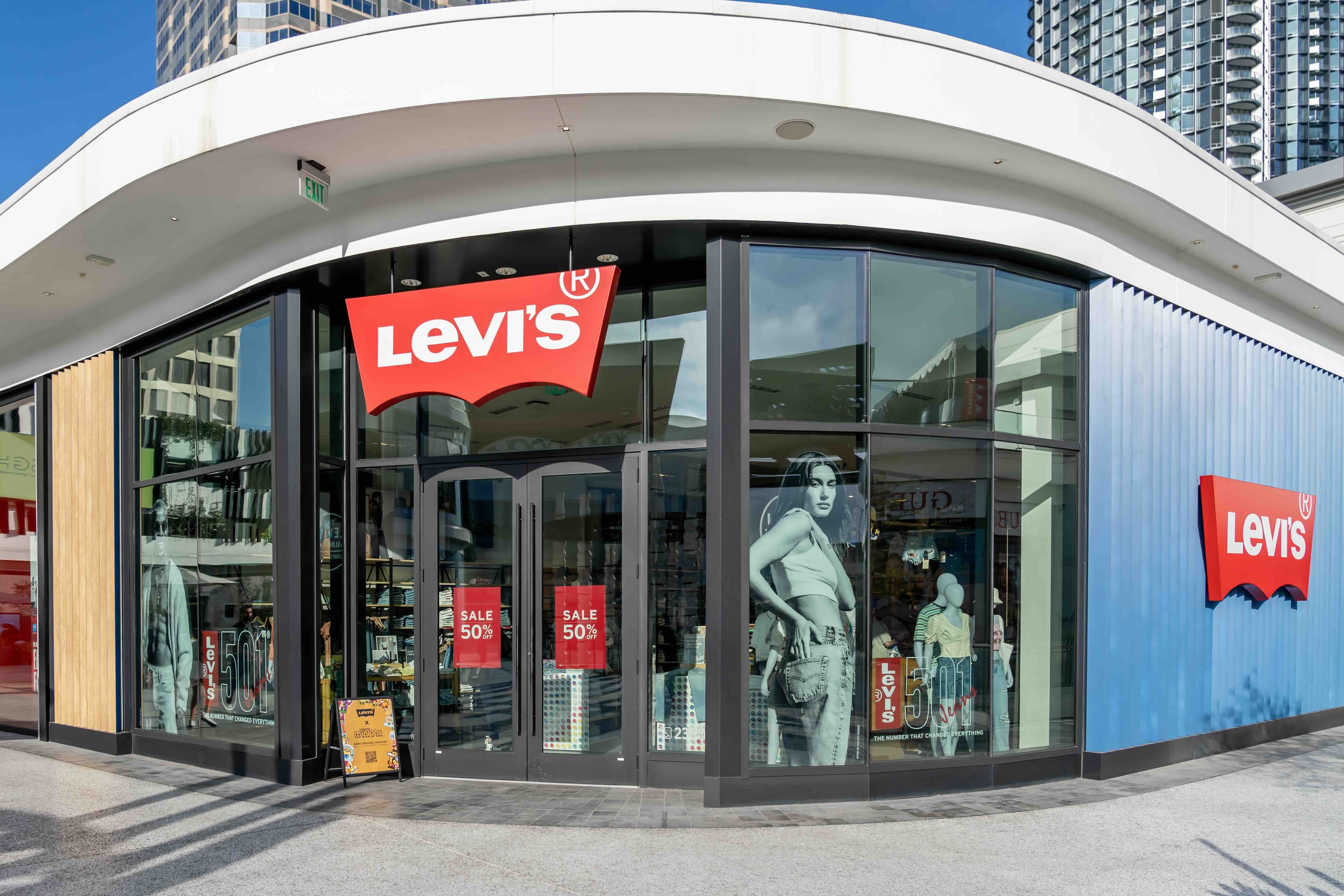 Levi's retail storefront with red logo and sale signs in modern shopping center