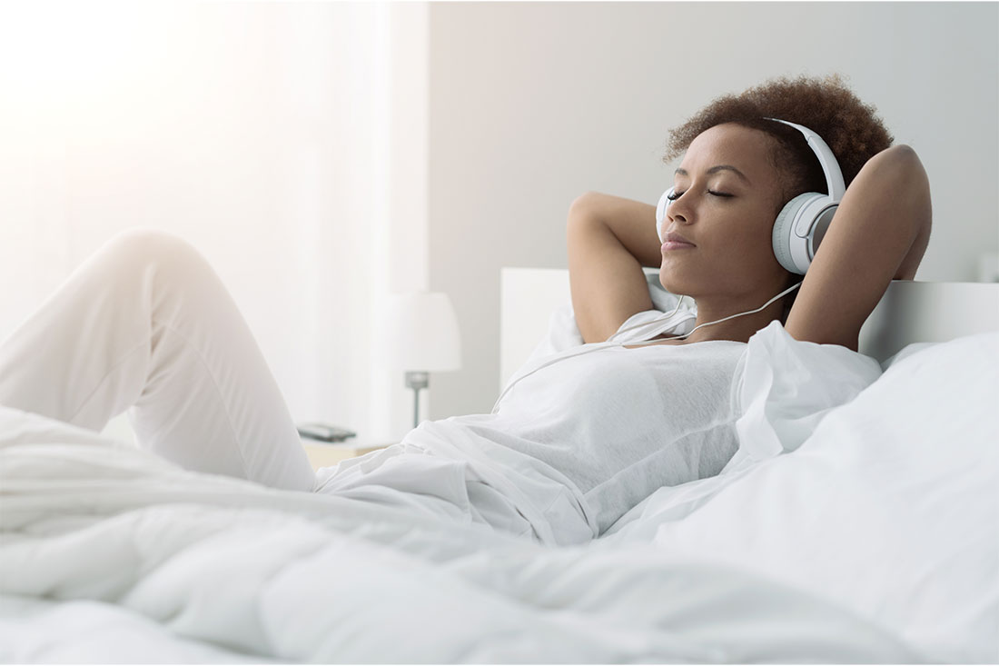 woman relaxing and listening to music using headphones