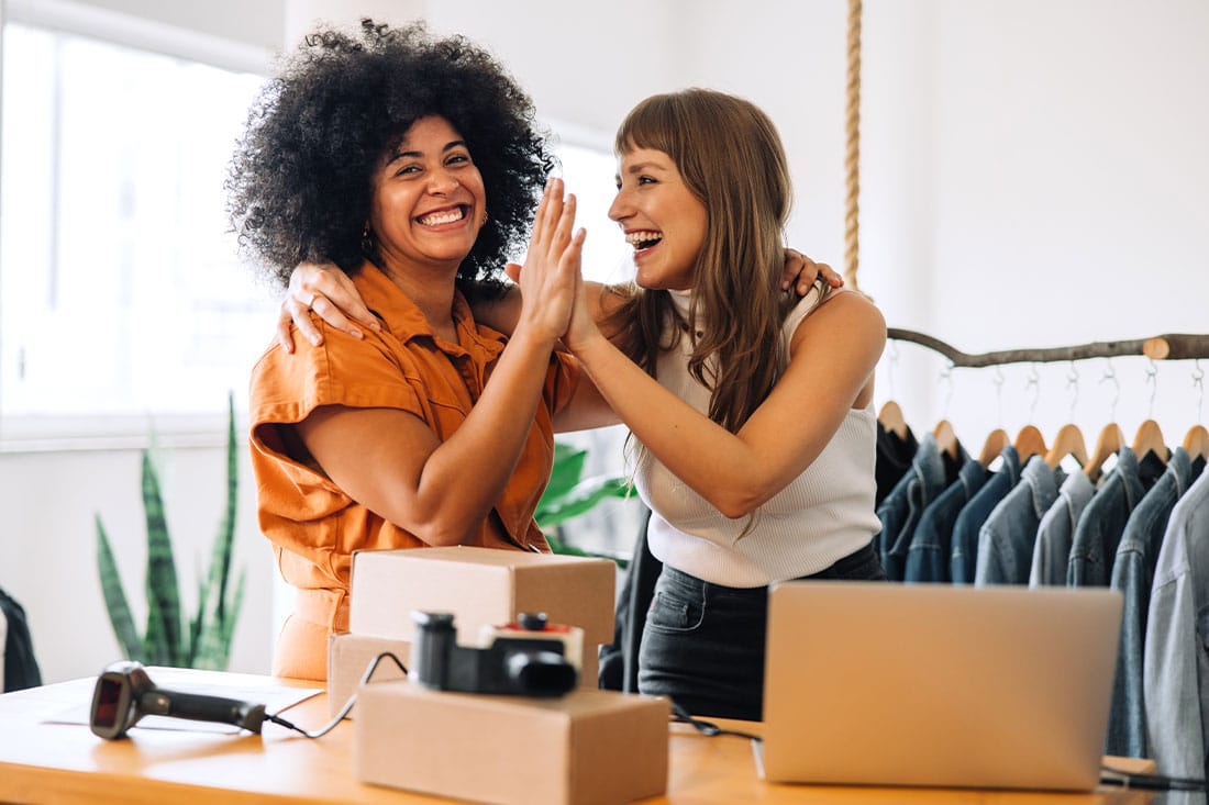 Cheerful business owners high-fiving each other