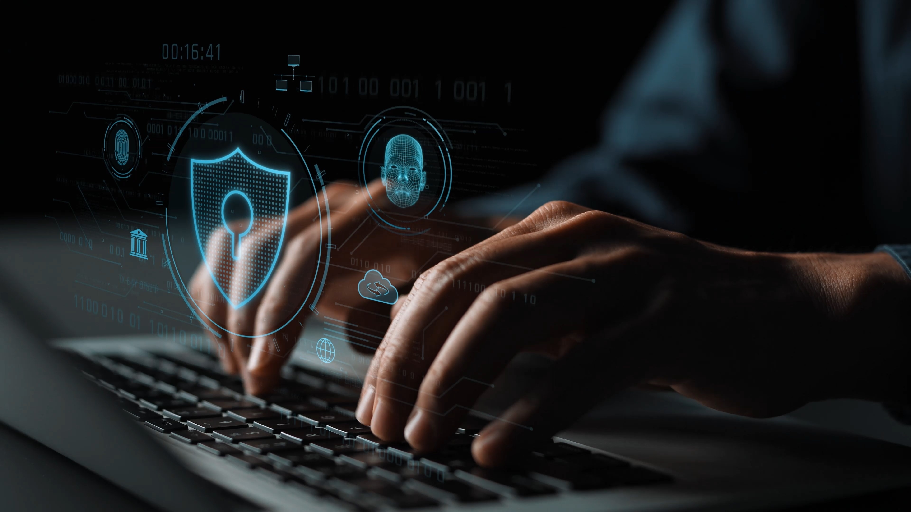 Person typing on laptop with holographic cybersecurity icons including shield, biometric scan, and cloud symbols overlaid