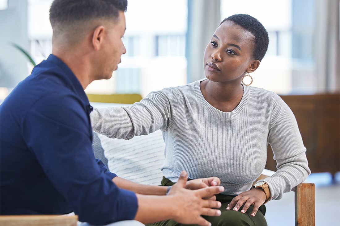 woman in office consoling man in stress, mental health support in workplace