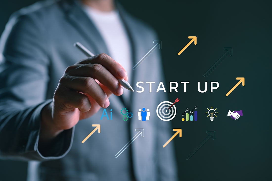 Businessman writing "Start Up" with digital icons of AI,