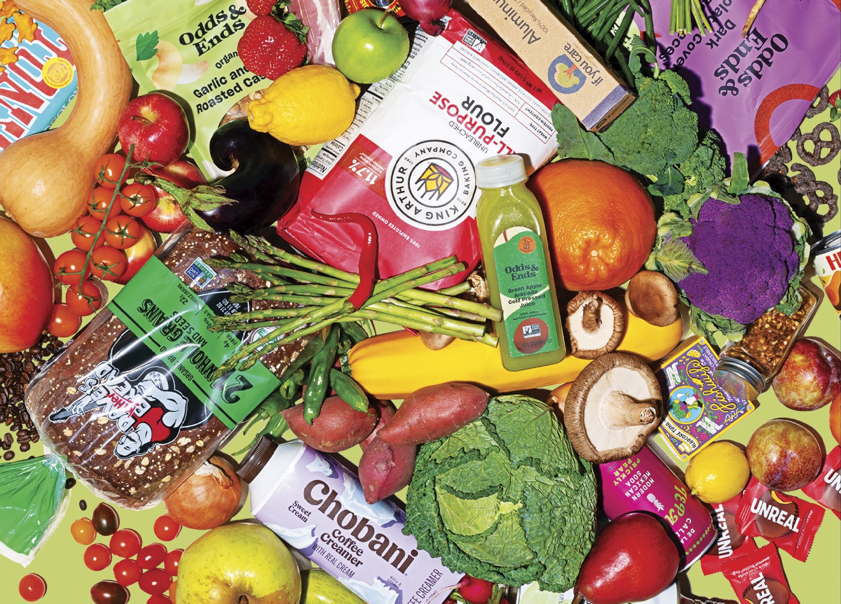 Assortment of organic food products including fresh produce, bread, and packaged goods from sustainable brands