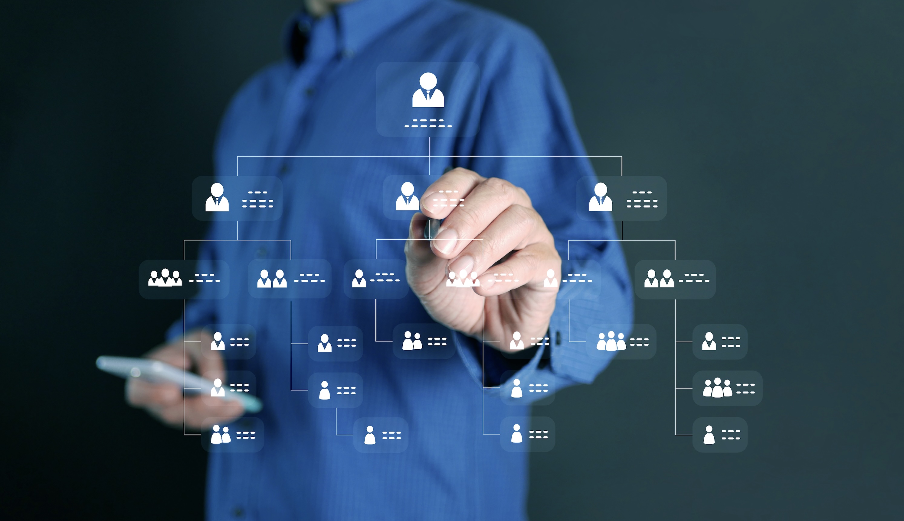 Businessman drawing organizational hierarchy chart showing complex multi-level structure with interconnected teams