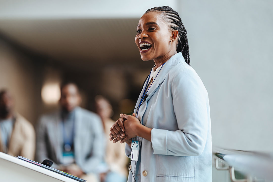 woman in blazer speaking in front of a group