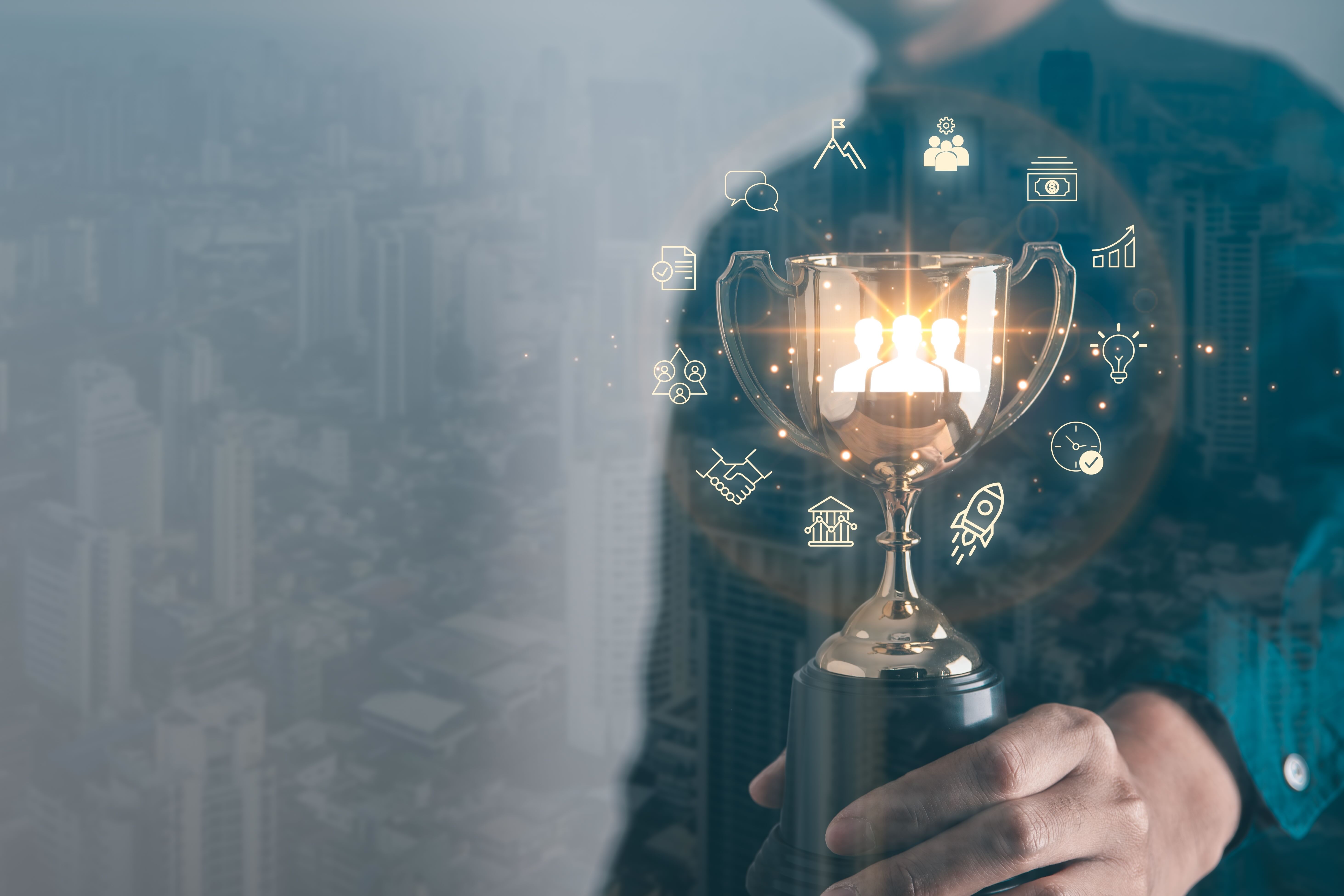 Business person holding trophy with glowing icons representing teamwork, innovation, and growth surrounding it