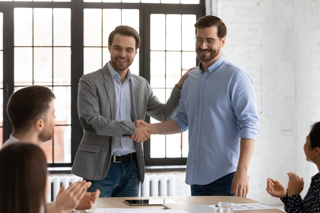 boss shakes hands with employee