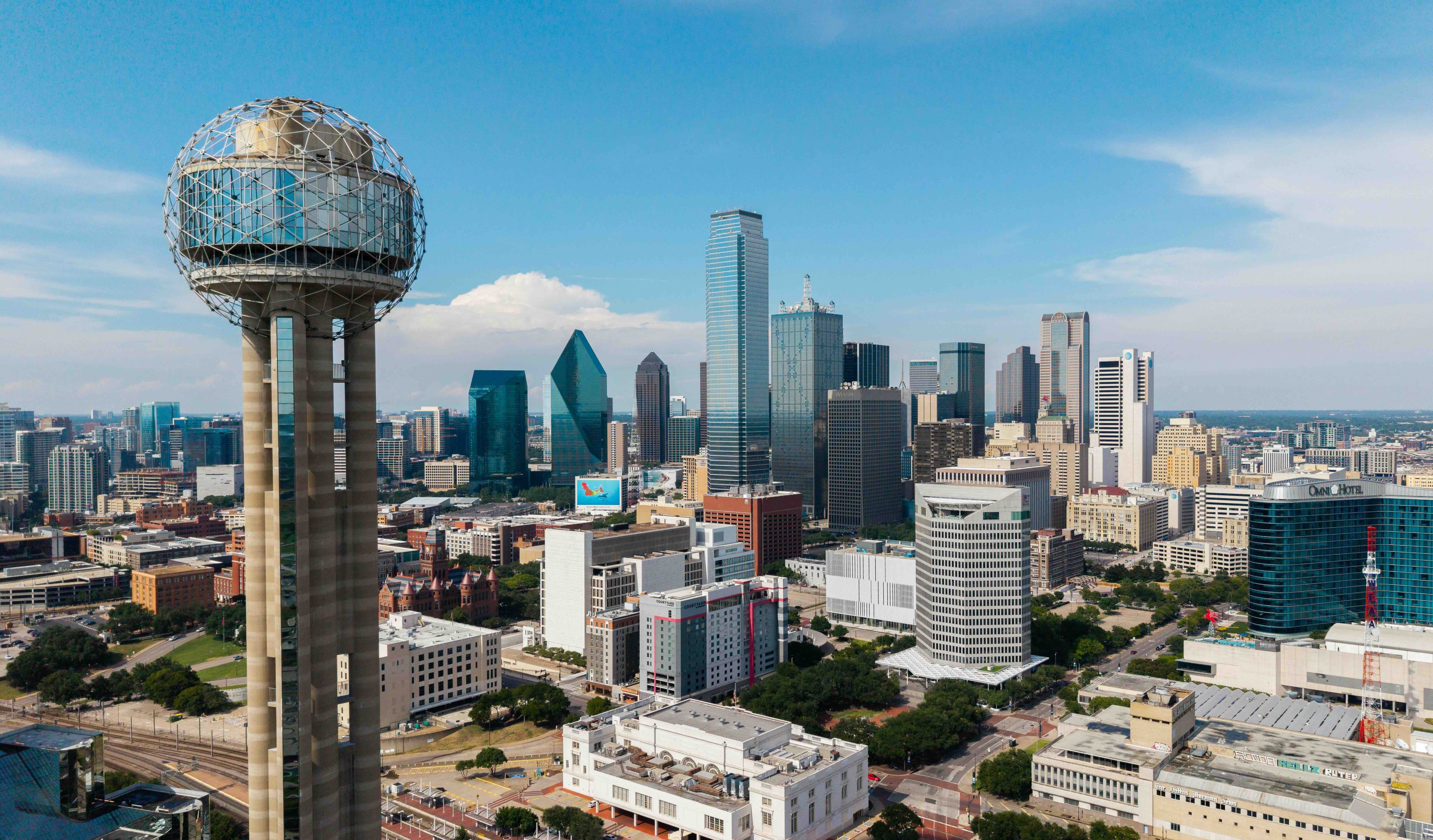 Dallas skyline featuring Reunion Tower and modern skyscrapers under blue sky