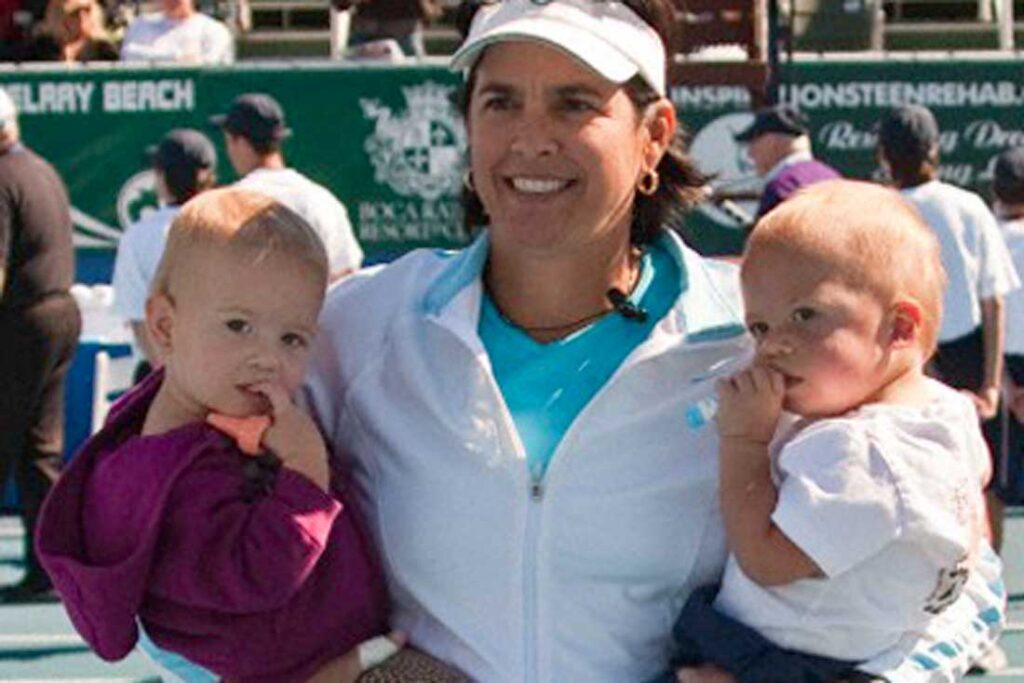 Gigi Fernandez holding her twins