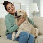 woman cuddling with dog on the couch