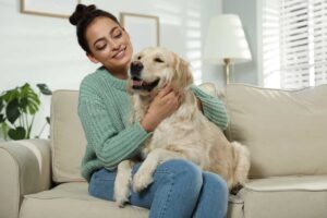 woman cuddling with dog on the couch