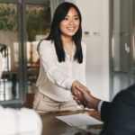 asian woman shaking hands with business investor