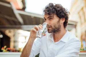 Man drinking water because he gave up alcohol for Lent