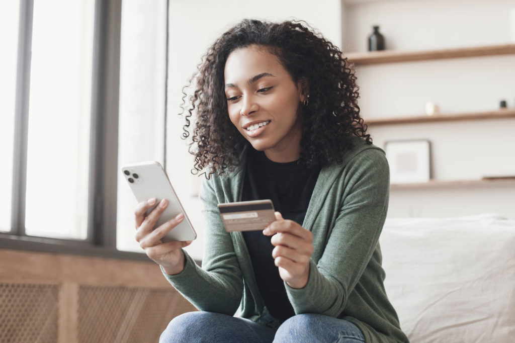 woman holding phone and credit card