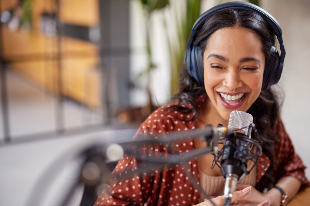 Young women smiling while showing how to start a podcast