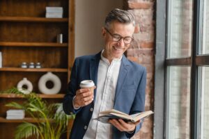 well-dressed successful man engaging in daily habit of reading a book