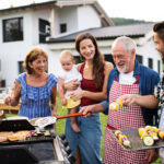 Portrait of multigeneration family outdoors on garden barbecue, grilling