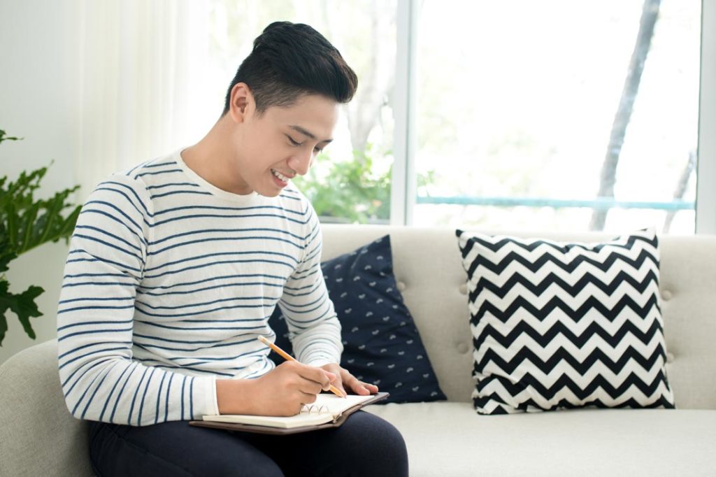 young man doing daily journaling