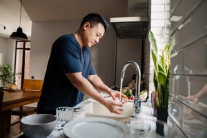man washing dishes at home