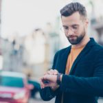 man looking at watch to stop being late