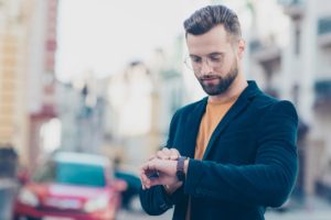 man looking at watch to stop being late