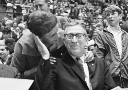 Nellie Riley kissing Coach John Wooden on the cheek