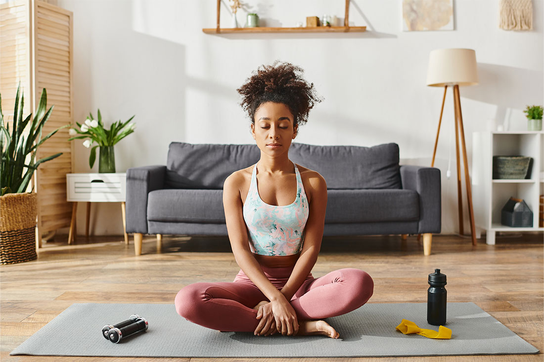 woman in activewear practicing yoga on a mat in a cozy living room setting
