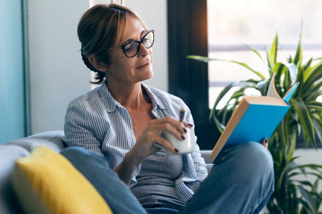 woman reading book to focus on personal growth and development