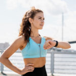 A woman uses a smart watch while exercising