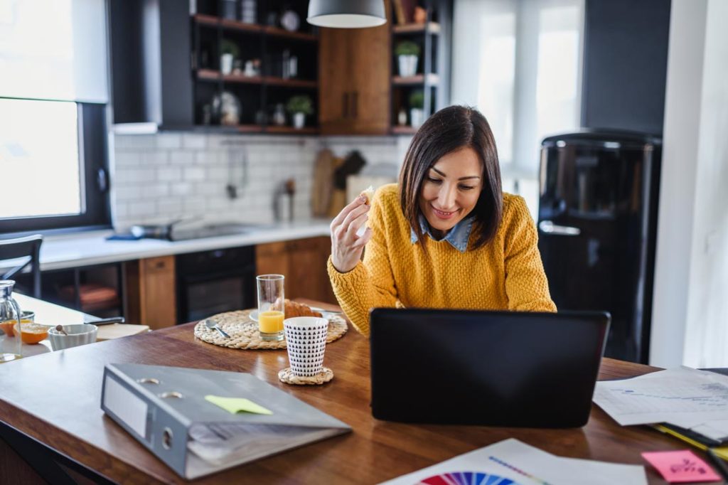 woman learning how to be more productive while eating breakfast