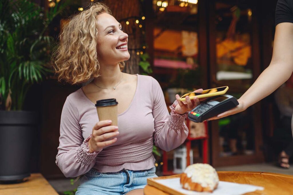 woman paying for coffee at cafe