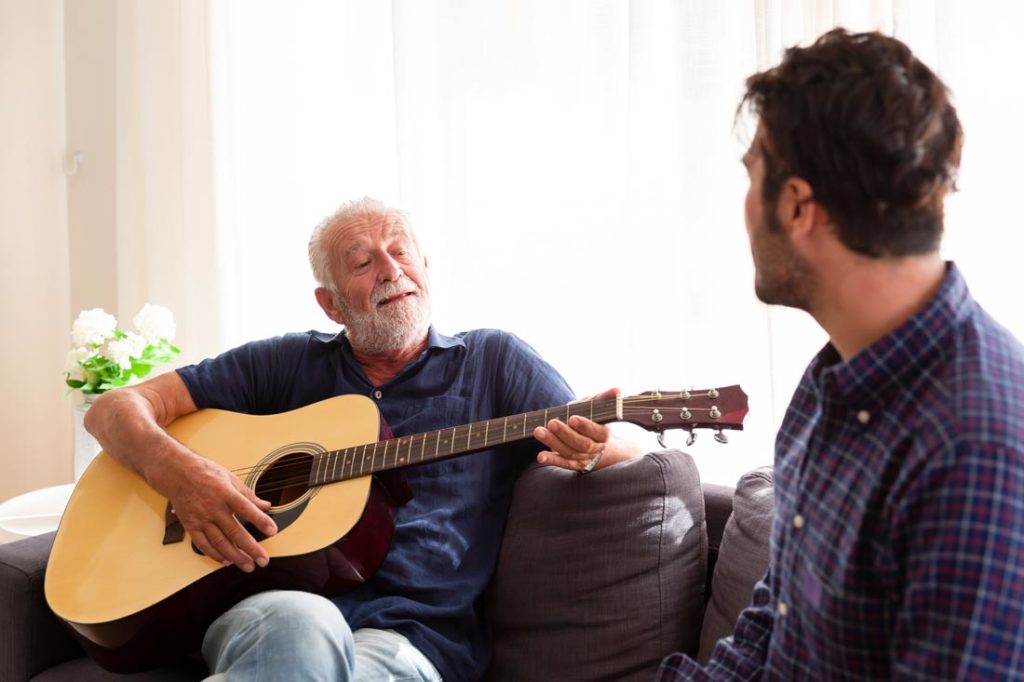 older man trying new things playing guitar