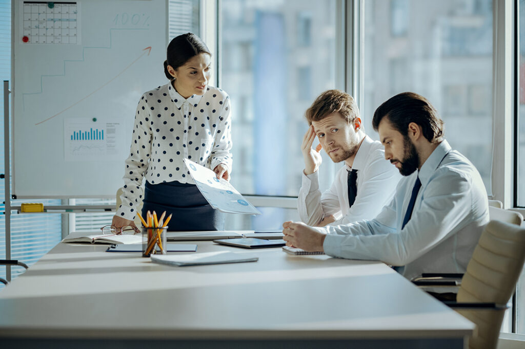 angry woman yelling at two male coworkers