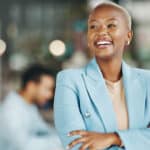 black woman with smile and arms crossed in office