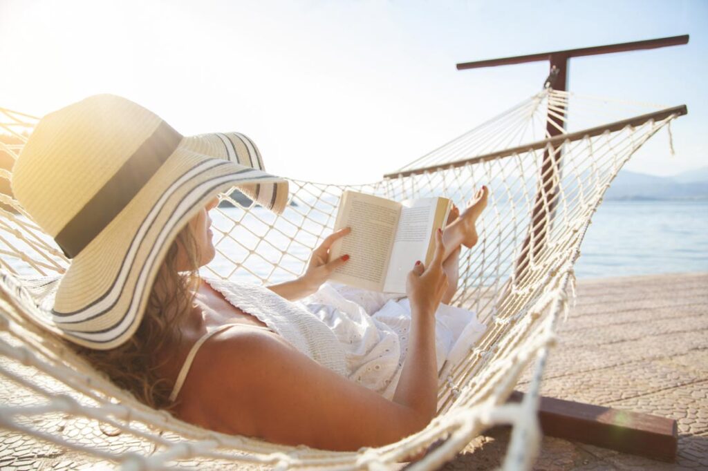 woman reading a self-improvement book at the beach during the summer