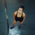 Young women looks up at rope to climb. Resilience quotes