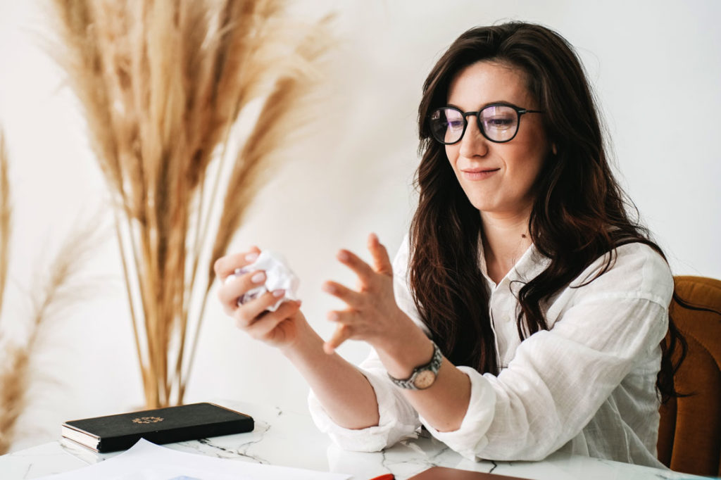 woman crumpling list of stupid new years resolutions