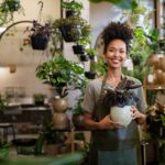 Smiling small business owner holding a plant