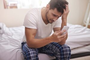upset man looking at phone