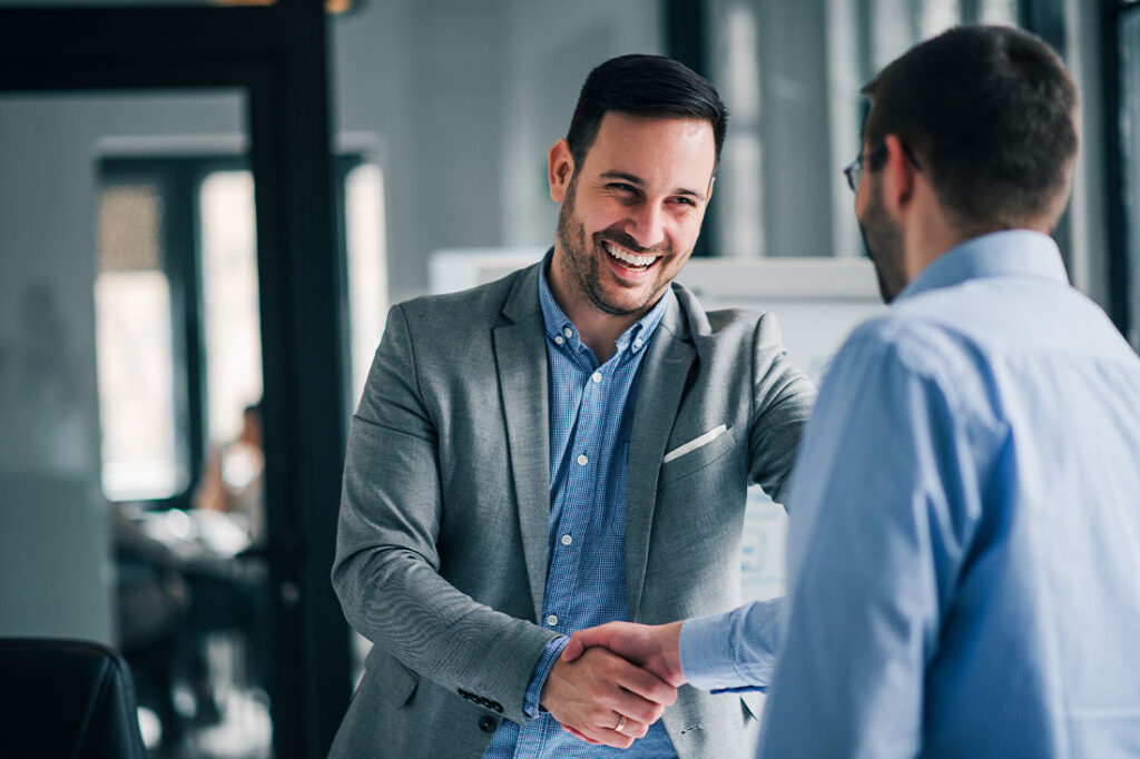 Portrait of cheerful young manager handshake with new employee