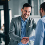 Portrait of cheerful young manager handshake with new employee