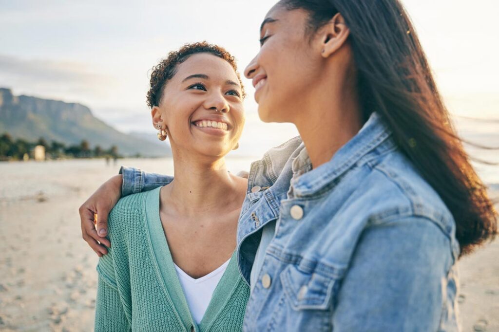 Lesbian couple on vacation smiling at each other because they know how to keep their relationship strong and happy