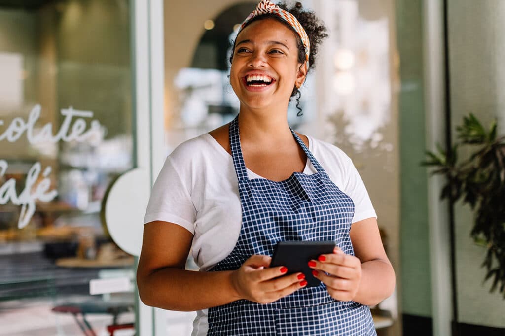 Happy young entrepreneur in front of cafe