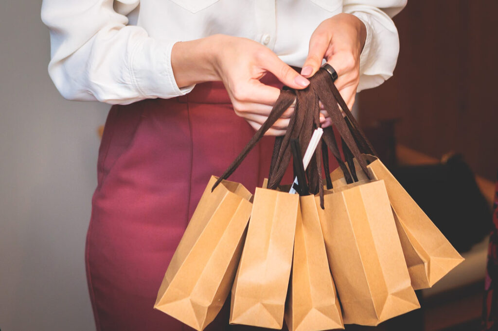 Corporate manager holding corporate gift ideas in small brown paper gift bags