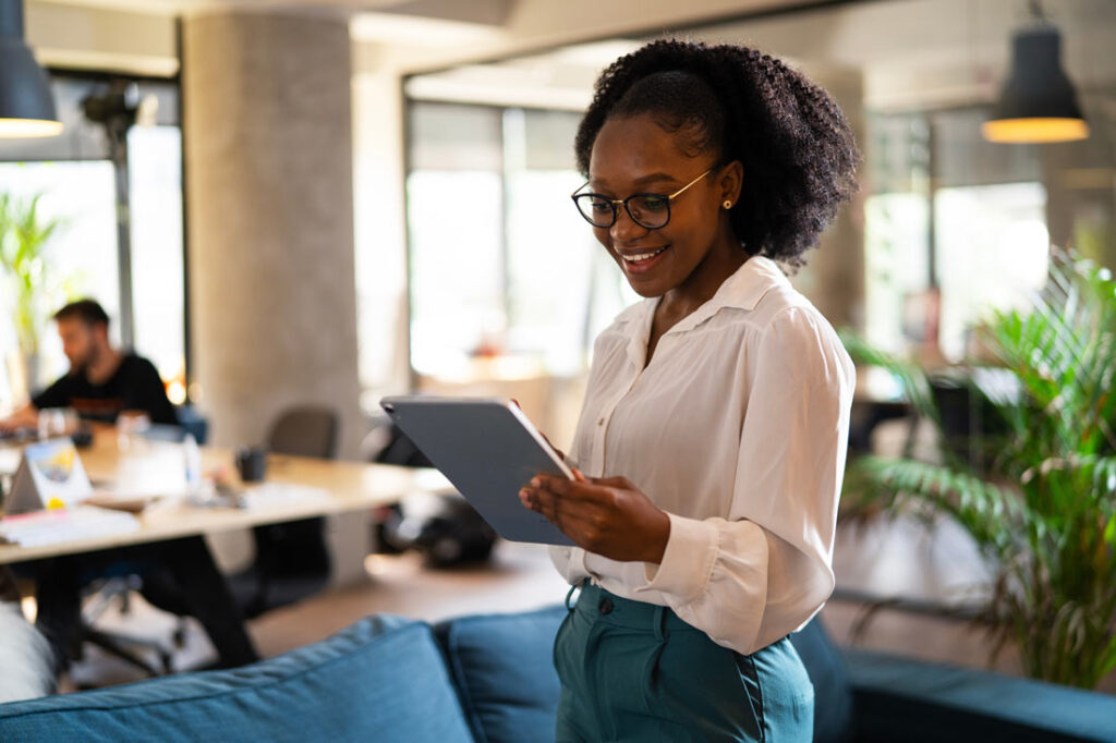 Young black business woman looking at the best goal setting worksheets on her ipad in the office